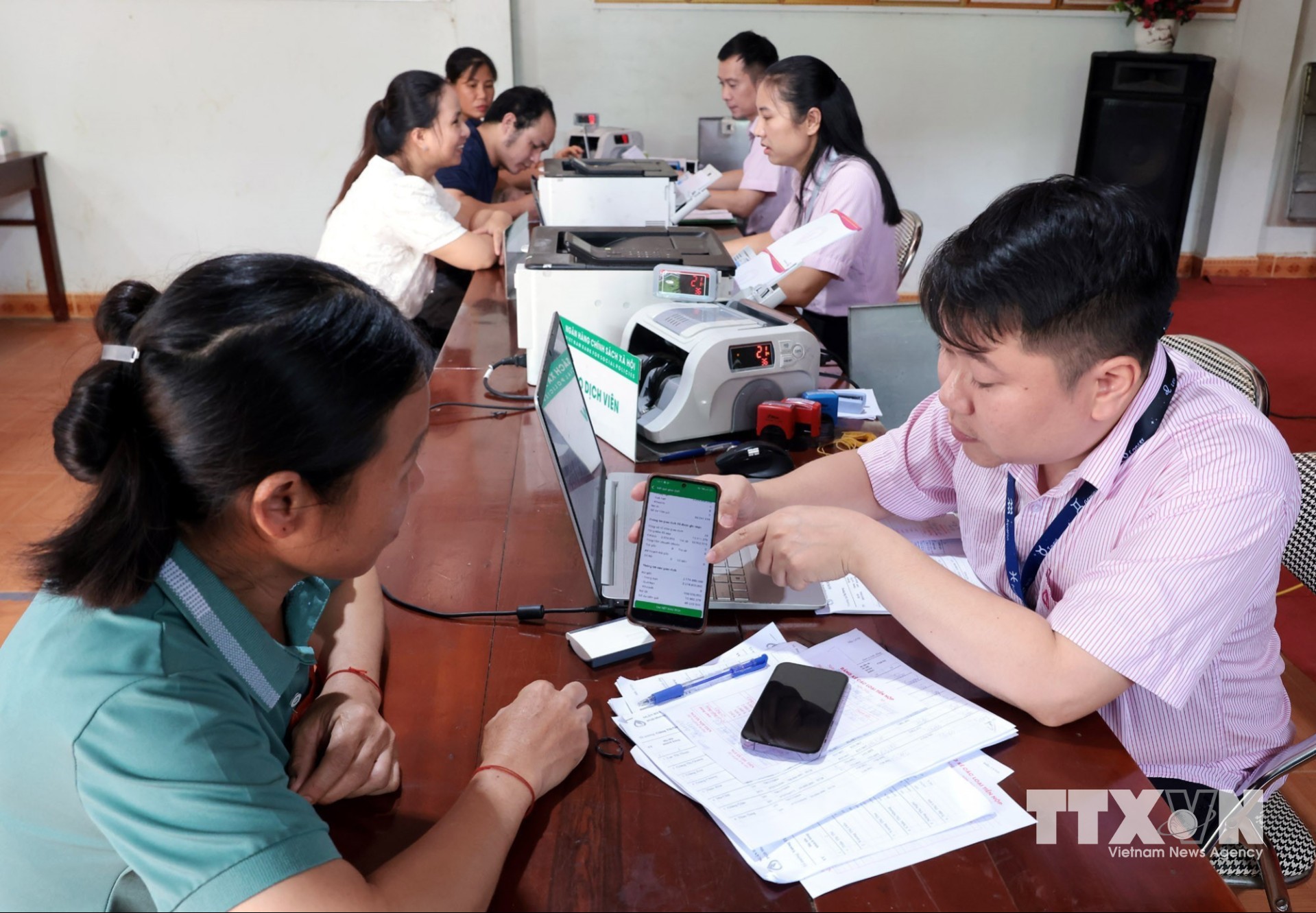 Tổ trưởng Tổ Tiết kiệm và vay vốn sử dụng phần mềm trên điện thoại để giao dịch tại điểm giao dịch xã Bản Lầu, Lào Cai. (Ảnh: Trần Việt/TTXVN)